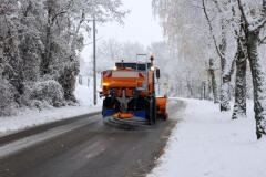 Snow Plow Spreading Salt on a Snowy Road During Winter 