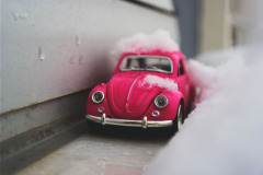 A picture of a miniature VW Bug with soap suds all over it.