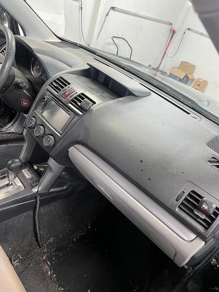 The SUV's dash that has a layer of dust and dirt on it. This is before the interior detailing service by Andy's Autowash.