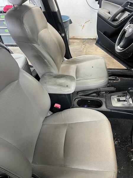 The center console and tan seats before it had an interior detailing by Andy's Autowash. Black spots on the seats & arm rest.