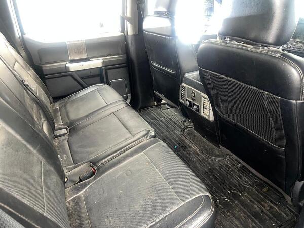 The back seats of a Ford F350 with dirt on the floorboards and seats. This is before it is detailed by Andy's Autowash.