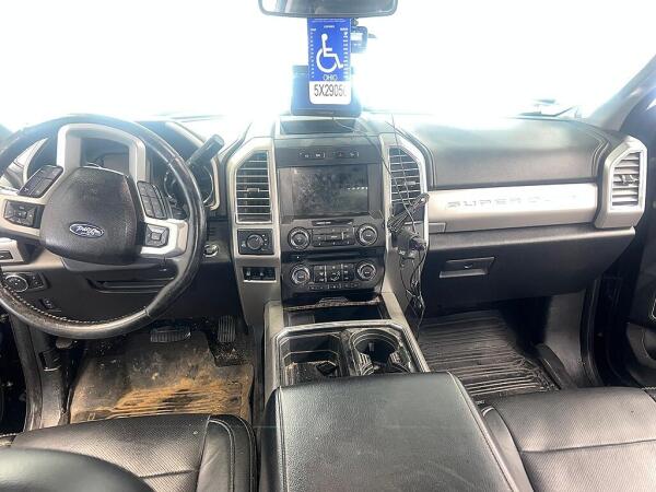 The front cab of an F350 showing the dirty floorboards and cupholders before the interior detailing by Andy's Autowash.