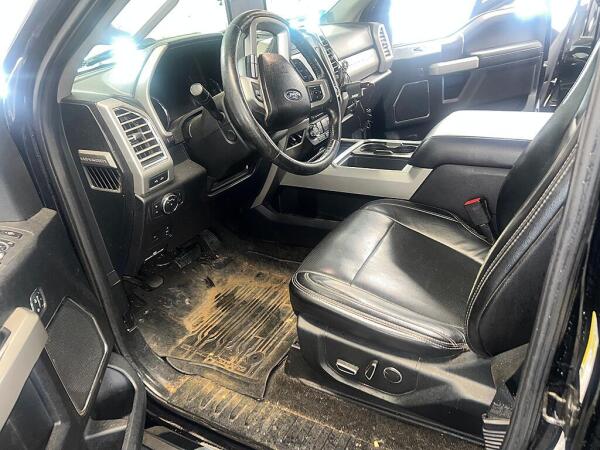 The driver's side interior of a F350 that is full of dirt and dust before it is cleaned by Andy's Autowash.