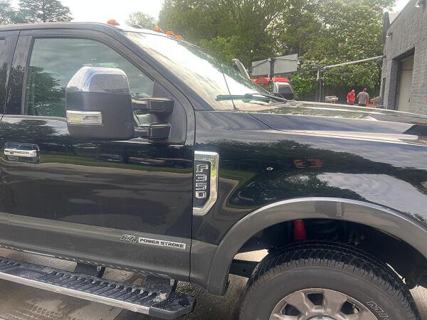 The outside of the front passenger's side and hood of the Ford F350 after it has exterior detailing by Andy's Autowash.