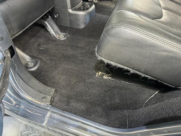 The interior detailed rear driver side seat and floor with no pet hair. Showing how clean Andy's Autowash got the inside.