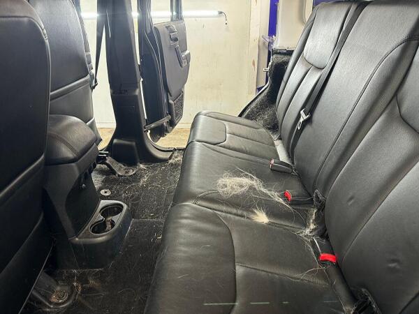Pet hair on the back seat and floor before it had the interior detailing service by Andy's Autowash & Detailing.