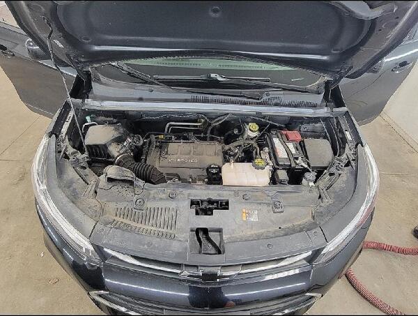 A closer view of under the hood of a car. Showing the caked on dirt & oil on the engine & parts before the engine cleaning.