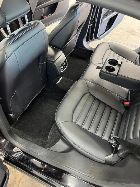The rear drivers side seat of a Ford car after it was cleaned by Andy's Autowash. Showing the shiny seat & spot free carpet.