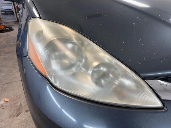 A cloudy driver's side headlight before it had the Headlight Restoration service by Andy’s Autowash. 