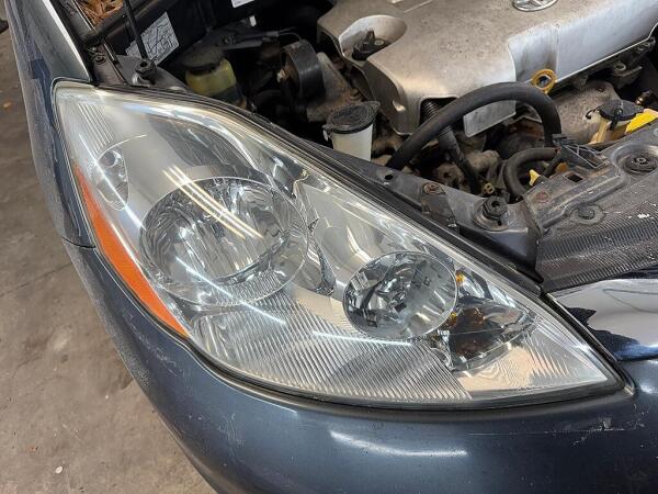 A clear passenger's side headlight after it had the exterior detailing service of Headlight Restoration at Andy's Autowash.